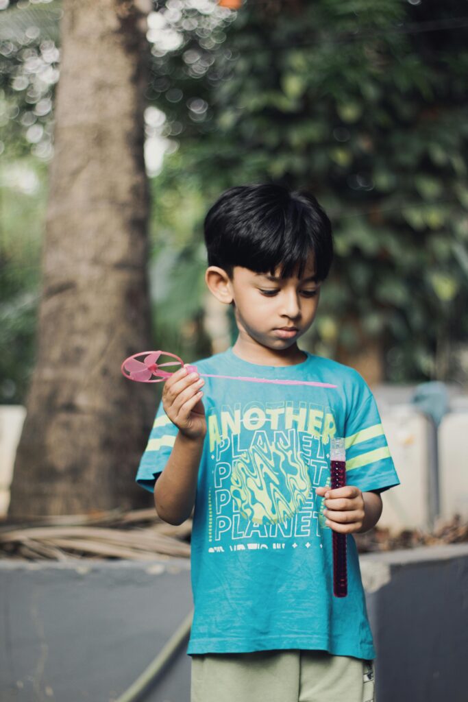 A cute child with a bubble wand enjoys a playful day outdoors.